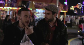 Movie still from “Weekend” (2011), directed by Andrew Haigh – Two men standing next to each other on the street; Close Up shot, Over the shoulder angle