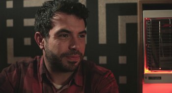 Movie still from “Weekend” (2011), directed by Andrew Haigh – A person wearing a red shirt; Close Up shot, Over the shoulder angle