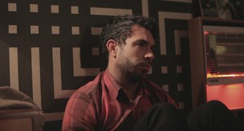 Movie still from “Weekend” (2011), directed by Andrew Haigh – A person wearing a red shirt; Close Up shot, High angle