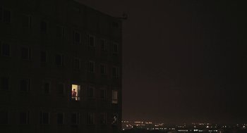 Movie still from “Weekend” (2011), directed by Andrew Haigh – A person standing on a window ledge at night; Extreme Wide shot, Low angle