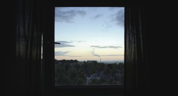 Movie still from “Weekend” (2011), directed by Andrew Haigh – A view from a window looking out on a city; Extreme Wide shot, Low angle