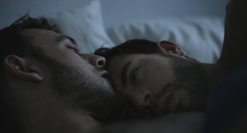 Movie still from “Weekend” (2011), directed by Andrew Haigh – A man laying in bed with his head resting on his chest; Extreme Close Up shot, Overhead angle