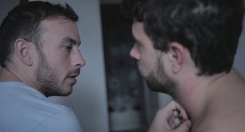 Movie still from “Weekend” (2011), directed by Andrew Haigh – Two men looking at each other in a room; Close Up shot, Over the shoulder angle