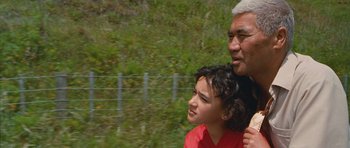 Movie still from “Whale Rider” (2002), directed by Niki Caro – An older man and a young boy are standing next to each other; Close Up shot, Over the shoulder angle