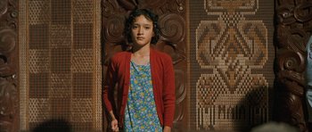 Movie still from “Whale Rider” (2002), directed by Niki Caro – A girl in a blue dress and a red sweater; Medium shot, Low angle