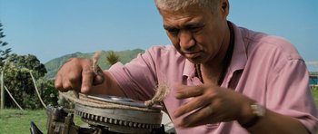 Movie still from “Whale Rider” (2002), directed by Niki Caro – An older man working on something in a pot; Close Up shot, Low angle