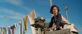 Movie still from “Whale Rider” (2002), directed by Niki Caro – A woman standing next to an outboard motor on a boat; Medium shot, Low angle