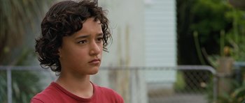 Movie still from “Whale Rider” (2002), directed by Niki Caro – A young boy with curly hair is looking to his left; Close Up shot, Low angle