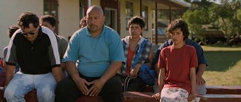 Movie still from “Whale Rider” (2002), directed by Niki Caro – A group of people sitting on a bench; Medium shot, Over the shoulder angle