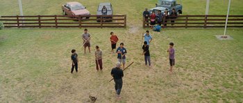Movie still from “Whale Rider” (2002), directed by Niki Caro – A group of people standing in a field holding baseball bats; Wide shot, High angle