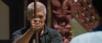 Movie still from “Whale Rider” (2002), directed by Niki Caro – An older man holding a wooden pole in front of a wall; Close Up shot, Over the shoulder angle