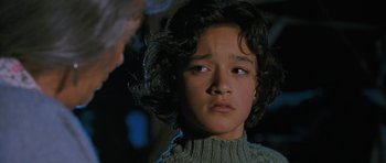 Movie still from “Whale Rider” (2002), directed by Niki Caro – A young boy with curly black hair looking at the camera; Close Up shot, Low angle