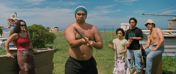 Movie still from “Whale Rider” (2002), directed by Niki Caro – A man holding a baseball bat while standing next to a girl; Medium shot, Over the shoulder angle