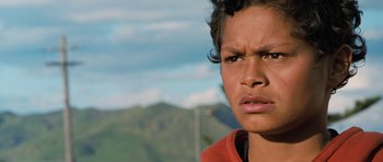 Movie still from “Whale Rider” (2002), directed by Niki Caro – A person looking angry with mountains in the background; Close Up shot, Low angle