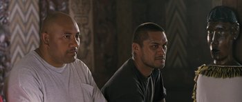 Movie still from “Whale Rider” (2002), directed by Niki Caro – Two men sitting next to each other in front of a wall; Close Up shot, Over the shoulder angle