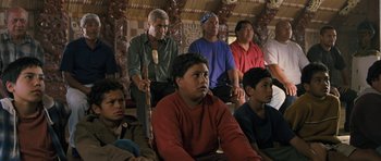 Movie still from “Whale Rider” (2002), directed by Niki Caro – A group of people sitting in a room; Medium shot, High angle