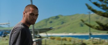 Movie still from “Whale Rider” (2002), directed by Niki Caro – A man standing in front of a body of water; Close Up shot, Over the shoulder angle