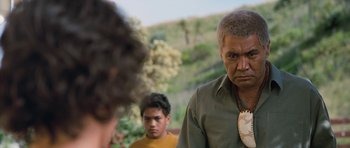 Movie still from “Whale Rider” (2002), directed by Niki Caro – A man in a green shirt is looking at another man in a yellow shirt; Close Up shot, Over the shoulder angle