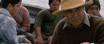 Movie still from “Whale Rider” (2002), directed by Niki Caro – An older man wearing a straw hat sitting on a boat; Close Up shot, Over the shoulder angle
