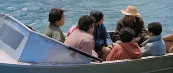 Movie still from “Whale Rider” (2002), directed by Niki Caro – A group of young men sitting in a row boat on a body of water; Wide shot, High angle