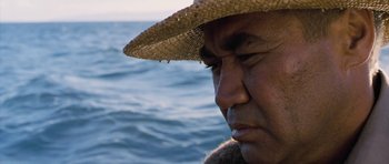 Movie still from “Whale Rider” (2002), directed by Niki Caro – An older man wearing a straw hat near the ocean; Close Up shot, Low angle