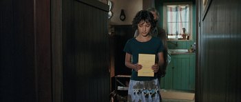 Movie still from “Whale Rider” (2002), directed by Niki Caro – A young woman holding a piece of paper in her hands; Medium shot, Over the shoulder angle