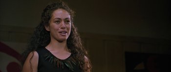 Movie still from “Whale Rider” (2002), directed by Niki Caro – A woman with long curly brown hair wearing a black top; Close Up shot, Over the shoulder angle