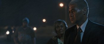 Movie still from “Whale Rider” (2002), directed by Niki Caro – A man and a woman standing next to each other in front of lights at night; Close Up shot, Over the shoulder angle