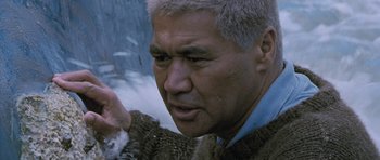 Movie still from “Whale Rider” (2002), directed by Niki Caro – An older man wearing a fur coat looking at the camera; Close Up shot, Low angle