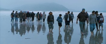 Movie still from “Whale Rider” (2002), directed by Niki Caro – A group of people walking along the beach; Extreme Wide shot, High angle