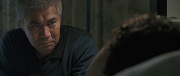 Movie still from “Whale Rider” (2002), directed by Niki Caro – An older man sitting in front of another man; Close Up shot, Over the shoulder angle