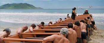 Movie still from “Whale Rider” (2002), directed by Niki Caro – A group of people sitting on top of a wooden boat; Wide shot, High angle