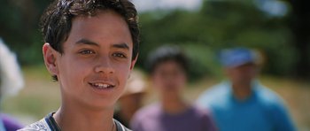 Movie still from “Whale Rider” (2002), directed by Niki Caro – A young man smiling for the camera; Close Up shot, Low angle