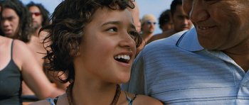 Movie still from “Whale Rider” (2002), directed by Niki Caro – A person smiling with other people in the background; Close Up shot, Low angle