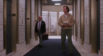 Movie still from “What About Bob?” (1991), directed by Frank Oz – Two men walking down a hall way in a building; Wide shot, Low angle