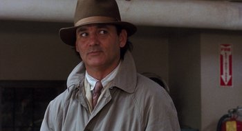 Movie still from “What About Bob?” (1991), directed by Frank Oz – A man wearing a hat and a trench coat; Close Up shot, Over the shoulder angle