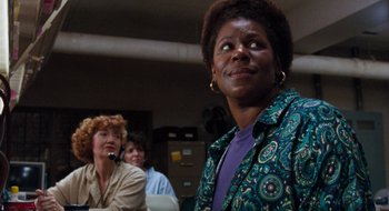 Movie still from “What About Bob?” (1991), directed by Frank Oz – A woman standing in front of other people; Close Up shot, Over the shoulder angle