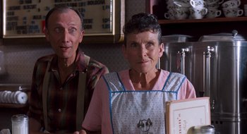Movie still from “What About Bob?” (1991), directed by Frank Oz – An older man standing next to an older woman in an apron; Close Up shot, High angle
