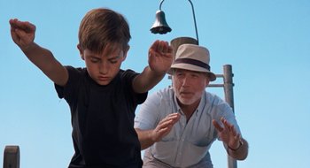 Movie still from “What About Bob?” (1991), directed by Frank Oz – An older man and a young boy standing next to each other; Medium shot, Low angle