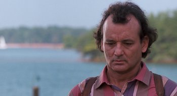 Movie still from “What About Bob?” (1991), directed by Frank Oz – A man in a striped shirt standing next to a body of water; Close Up shot, Over the shoulder angle