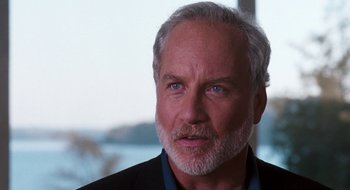 Movie still from “What About Bob?” (1991), directed by Frank Oz – An older man with grey hair wearing a black suit; Close Up shot, Over the shoulder angle