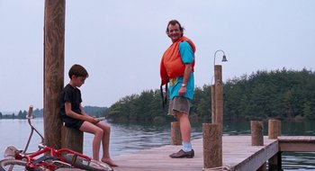 Movie still from “What About Bob?” (1991), directed by Frank Oz – A man standing on a pier next to a boy; Wide shot, Low angle