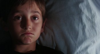 Movie still from “What About Bob?” (1991), directed by Frank Oz – A young boy laying in bed with his eyes wide open; Close Up shot, Low angle