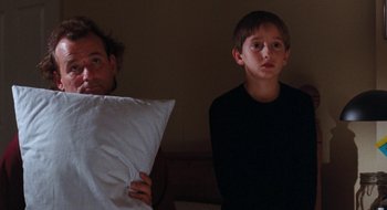 Movie still from “What About Bob?” (1991), directed by Frank Oz – A man and a boy in the dark holding pillows; Medium shot, Low angle