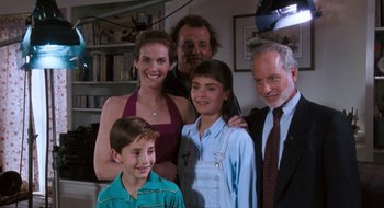 Movie still from “What About Bob?” (1991), directed by Frank Oz – A group of people posing for a picture in a room; Medium shot, High angle