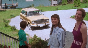 Movie still from “What About Bob?” (1991), directed by Frank Oz – A young girl standing next to an older car; Wide shot, High angle