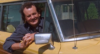 Movie still from “What About Bob?” (1991), directed by Frank Oz – A man sitting in the driver's seat of a yellow car; Medium shot, Low angle