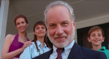 Movie still from “What About Bob?” (1991), directed by Frank Oz – An older man in a suit and tie with two other people in the background; Close Up shot, Low angle