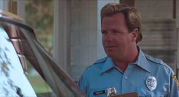 Movie still from “What About Bob?” (1991), directed by Frank Oz – A man in a blue shirt is looking at a clipboard; Close Up shot, Over the shoulder angle