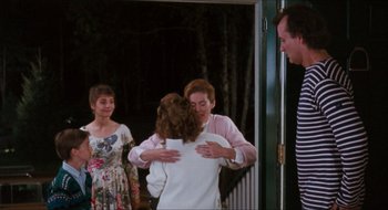 Movie still from “What About Bob?” (1991), directed by Frank Oz – A couple of people that are hugging in a room; Medium shot, Over the shoulder angle